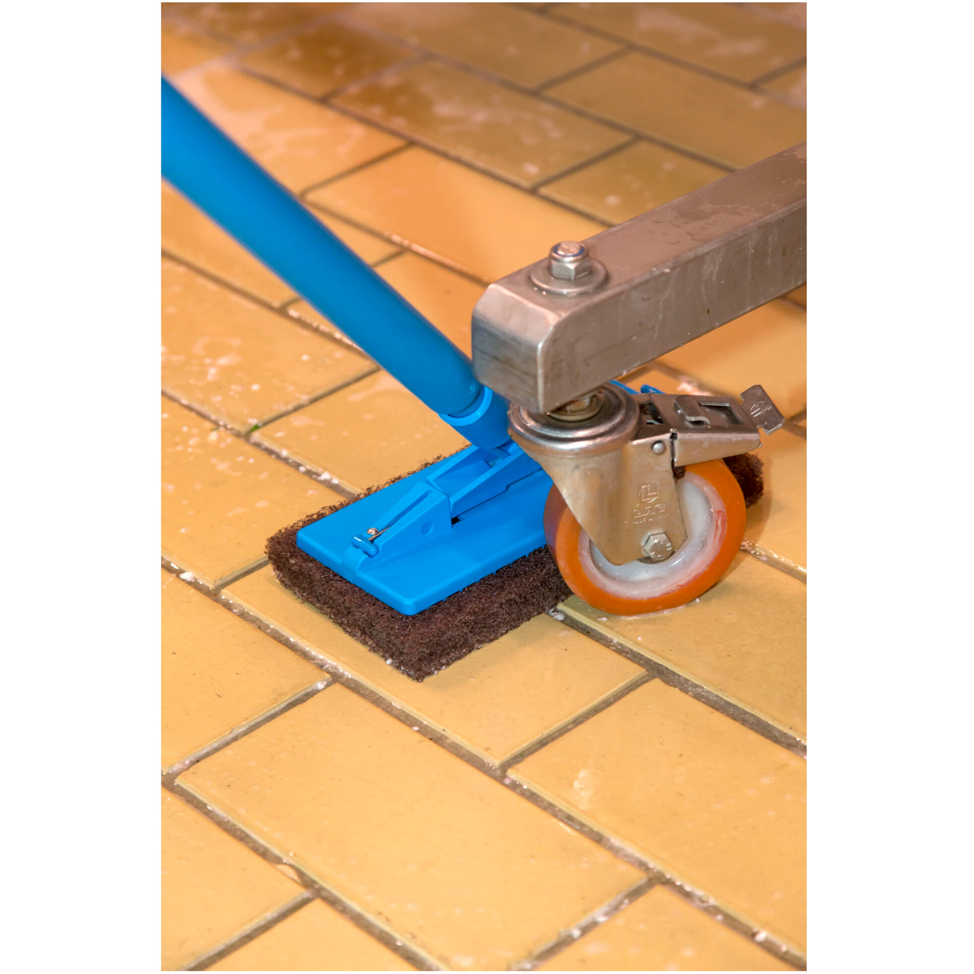 Vikan Padhalter mit braunem Scheuerpad bei der Bodenreinigung unter einem Fahrgestell